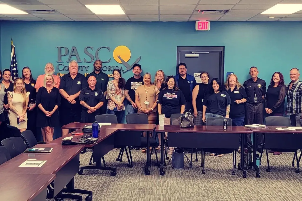 A Recovery Round Table group standing together in a Pasco County meeting room